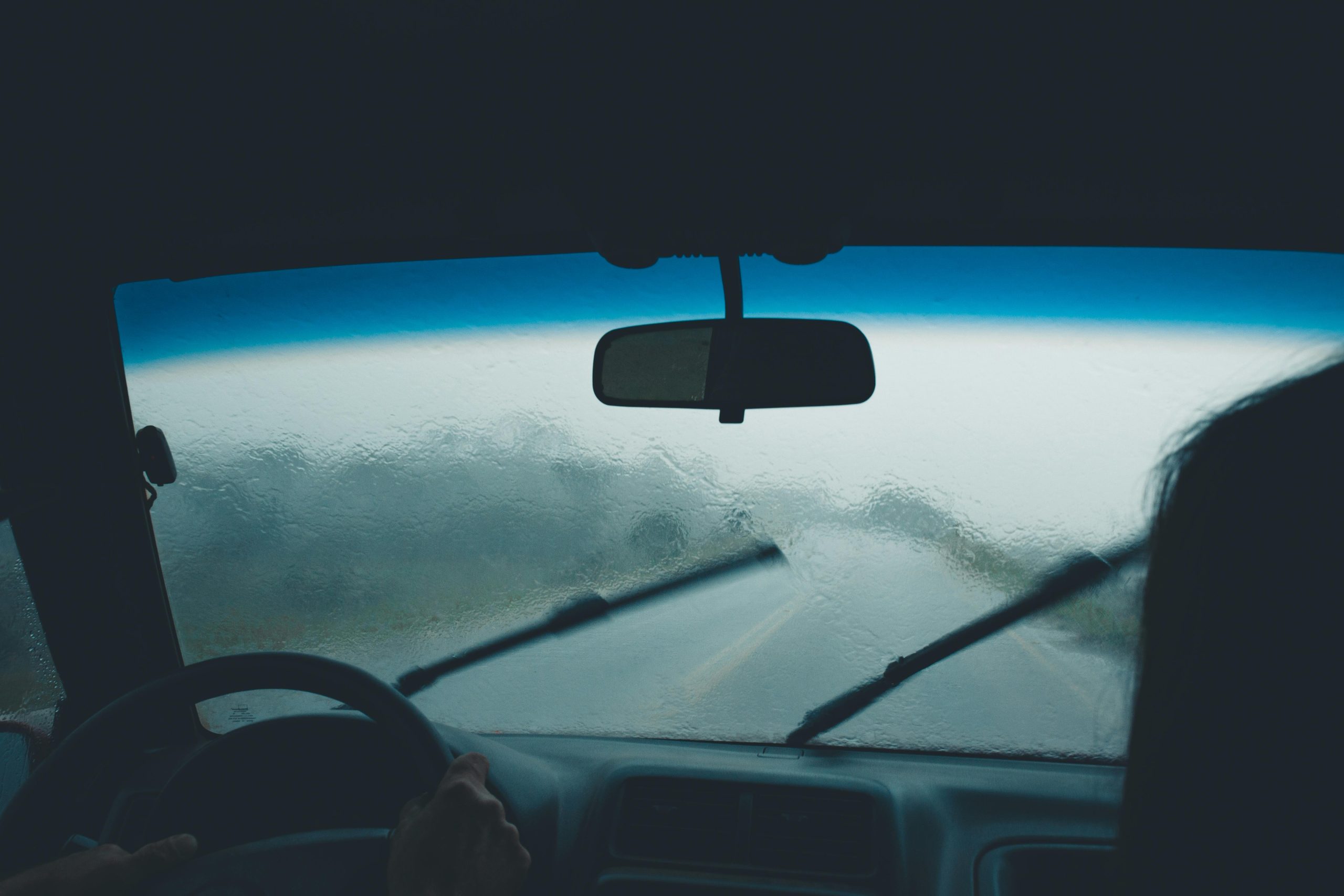 man driving in the rain while using wipers